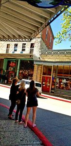 A lively street scene in Eureka Springs with people shopping and historic buildings.