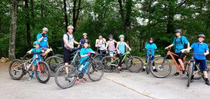 Cycling group enjoying a scenic ride in Eureka Springs' lush forest area.