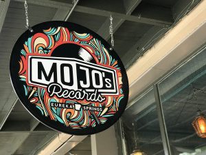 A colorful vintage record store sign for Mojo's Records in Eureka Springs, Arkansas.