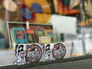 A colorful display of MOJO Jo's Records stickers and buttons at a local shop in Eureka Springs, Arka.