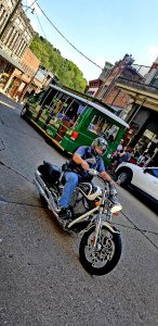 A vibrant street scene in Eureka Springs with a motorcyclist and historic buildings.
