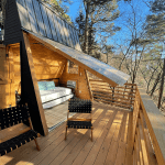 Relaxing outdoor wooden deck with seating and forest view in Eureka Springs, Arkansas.