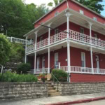 A charming red historic building with white balconies in Eureka Springs, Arkansas.
