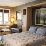 A cozy bedroom in Eureka Springs with natural light and scenic artwork.