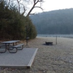 A picnic table and boat on the shore of a lake in Eureka Springs, Arkansas.