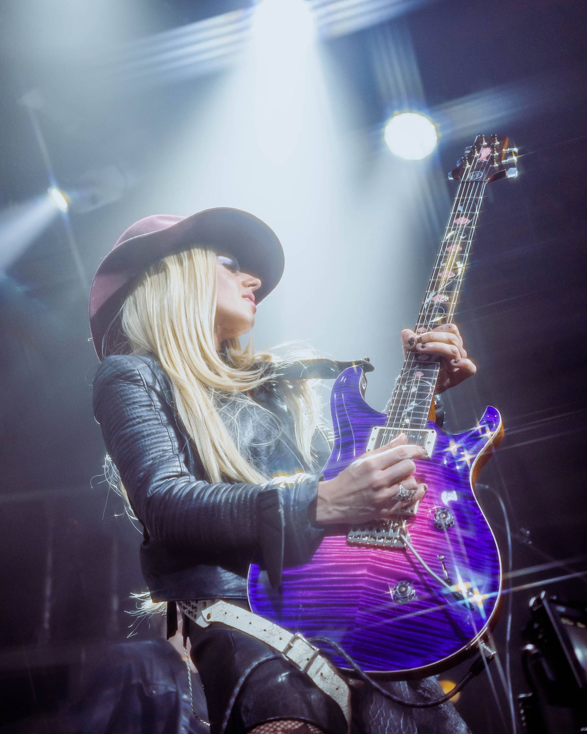 A vibrant female guitarist performing at the Eureka Springs Blues Festival, showcasing live music.